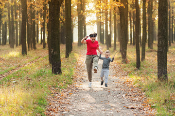 Obraz premium Mom and son have fun and fool around in the autumn park