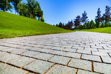 Stone walkway, lawn and trees in the park