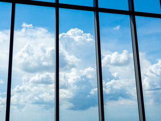 Beautiful clouds and blue sky through large windows, view from inside the building.