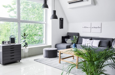 Stylish interior of living room with comfortable sofa and table