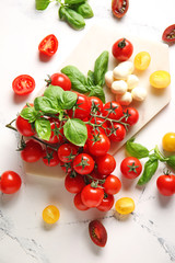 Composition with fresh cherry tomatoes, mozzarella cheese and spices on table