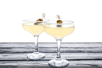 Glasses of fresh martini on table against white background