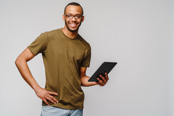 Portrait of a young african american man wearing glasses holding tablet pc pad