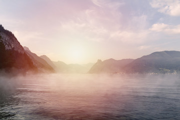 Fototapeta na wymiar Sunset on Traunsee lake with alps mountain and misty fog. Summer Austria landscape
