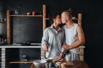 Young couple in love cook healthy food in the kitchen together. While kissing each other