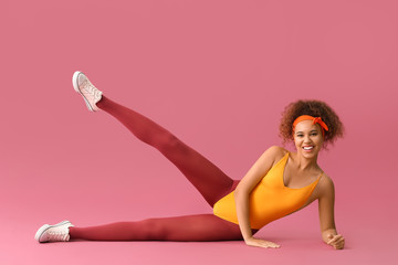 Young woman doing aerobics on color background