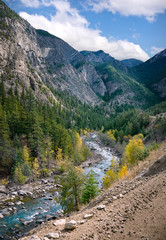 Fototapeta na wymiar Mountain Bridge River with turquoise clear water flows in the valley between the mountains with coniferous forest. Autumn landscape: colorful autumn trees in the valley. BC, Canada