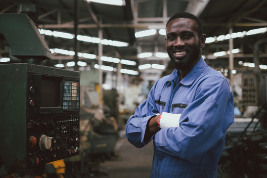 Factory african american worker or technician looking at camera and cross his arms with confident action.Industrial engineer at manufacturing plant.