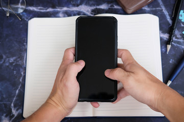 Businessman using a smartphone and working on the table