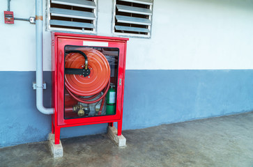 Fire extinguishers prepare in the event of fire, fire protection equipment in a red box beside the cement wall for the background, fire extinguishers on the outside walls