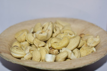 Cashews kept in a wooden cup with pure white background
