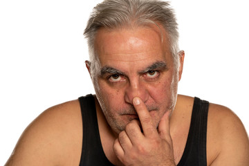 Obraz premium Concerned middle aged man touches his nose