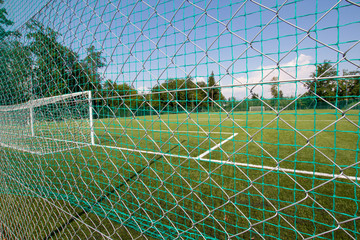 Soccer football goal in a large soccer football field. Isolated soccer goal