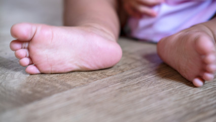 Baby feet on the wood floor. Toes horizontal photo.