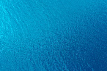 Fototapeta na wymiar Aerial view of a crystal clear sea water texture. View from above Natural blue background. Blue water reflection. Blue ocean wave. Summer sea. Drone. Top view