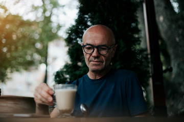a business man sitting on the street drinking coffee