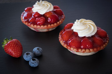 Tartlets with strawberries and whipped cream, close up