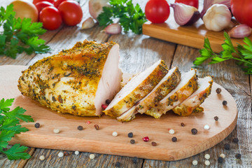Baked chicken fillet cut on a kitchen board