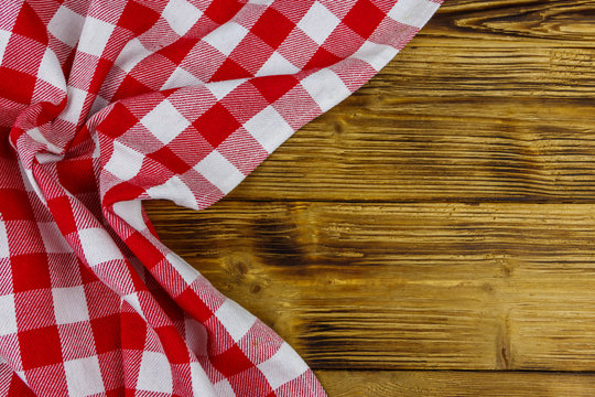 Red Folded Checkered Napkin On Rustic Wooden Kitchen Table. Top View, Copy Space