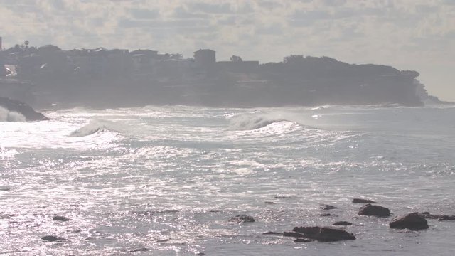 Waves crash at a beach in Malibu california during a summer morning