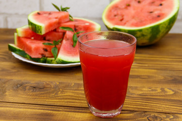 Glass of fresh watermelon juice on a wooden table