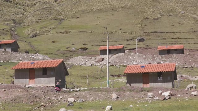 A Quechuan indigenous woman walking between the houses in Kelkanka, a remote community in the Peruvian Andes.