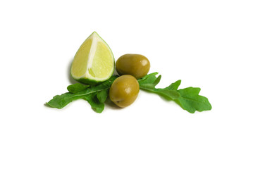 Two olives, piece of lemon and leaves of arugula isolated on white
