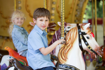 Children ride a retro horse carousel
