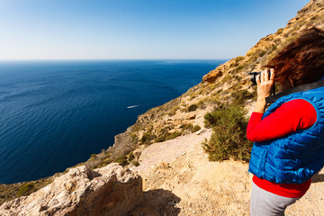 Woman take travel photo on sea coast, Spain