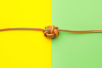 Rope with knot on color background