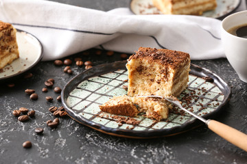 Plate with tasty tiramisu on dark background