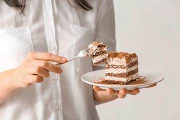 Woman eating tasty tiramisu, closeup