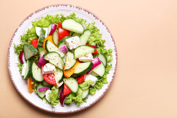 Plate with tasty cucumber salad on color background
