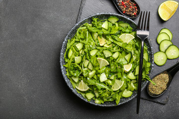 Plate with tasty cucumber salad on dark background