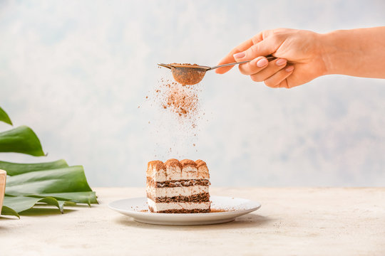 Woman Preparing Tasty Tiramisu On Table