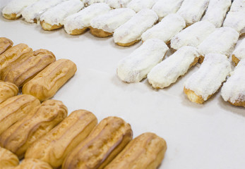 Fototapeta na wymiar Confectionery for the production of desserts and sweets, making custard cake eclairs with cream and coconut, delicatessen