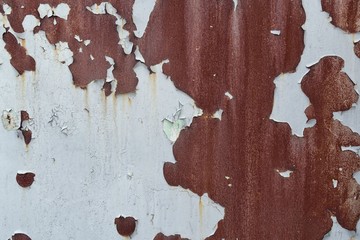 The texture of the old rusty worn metal, painted with white paint and peeling.