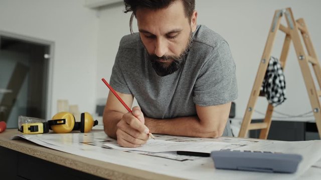 Handheld video of man calculating something using a calculator. Shot with RED helium camera in 8K