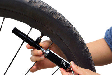 A cyclist using a tool to pump CO2 into a flat tire isolated on white background