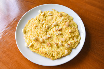 Omelette breakfast with macadamia nuts on top on white plate / Healthy food