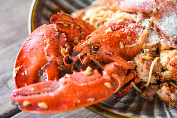 Shellfish seafood plate with lobster dinner food cooked - Grilled Lobster sausage ham vegetables and cheese spaghetti seafood on wooden table