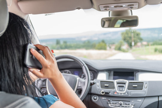 Femme t&eacute;l&eacute;phonant dans sa voiture