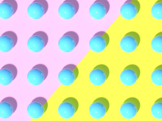 Pastel blue plastic shiny balls on a pale yellow and pink background. 3D render. Flat lay pattern style. Top view, aerial.