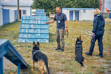 Professional dog trainers training security dogs outdoors