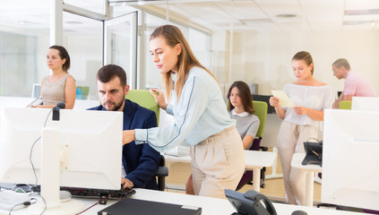 Fototapeta premium Successful businesswoman explaining something to male partner, pointing at computer monitor