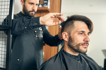 Profile photo of handsome man sitting in barbershop