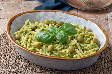 Pasta con pesto di olive verdi in pirofila di ceramica