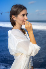 Close up portrait of beautiful woman with jewelry. Caucasian woman enjoying sunlight and looking to the ocean. Beauty and fashion concept.