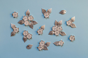 Silver details for creating jewelry, beading, and clothing design. Metal flowers and leaves, flat lay