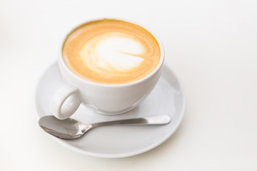 Coffee on a White Background. Coffee in a white cup with latte art. Flat lay, copy space.